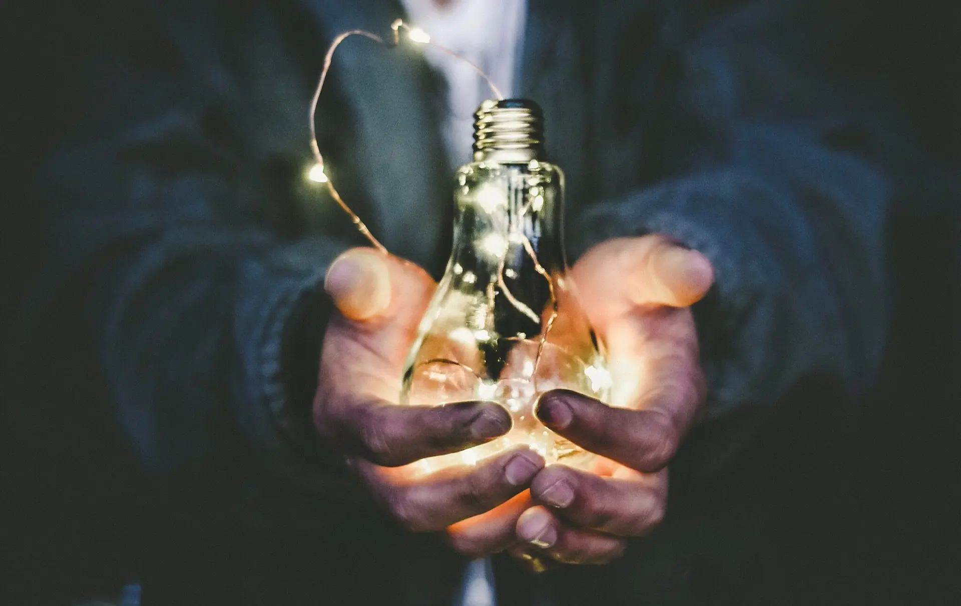 man holding incandescent bulb